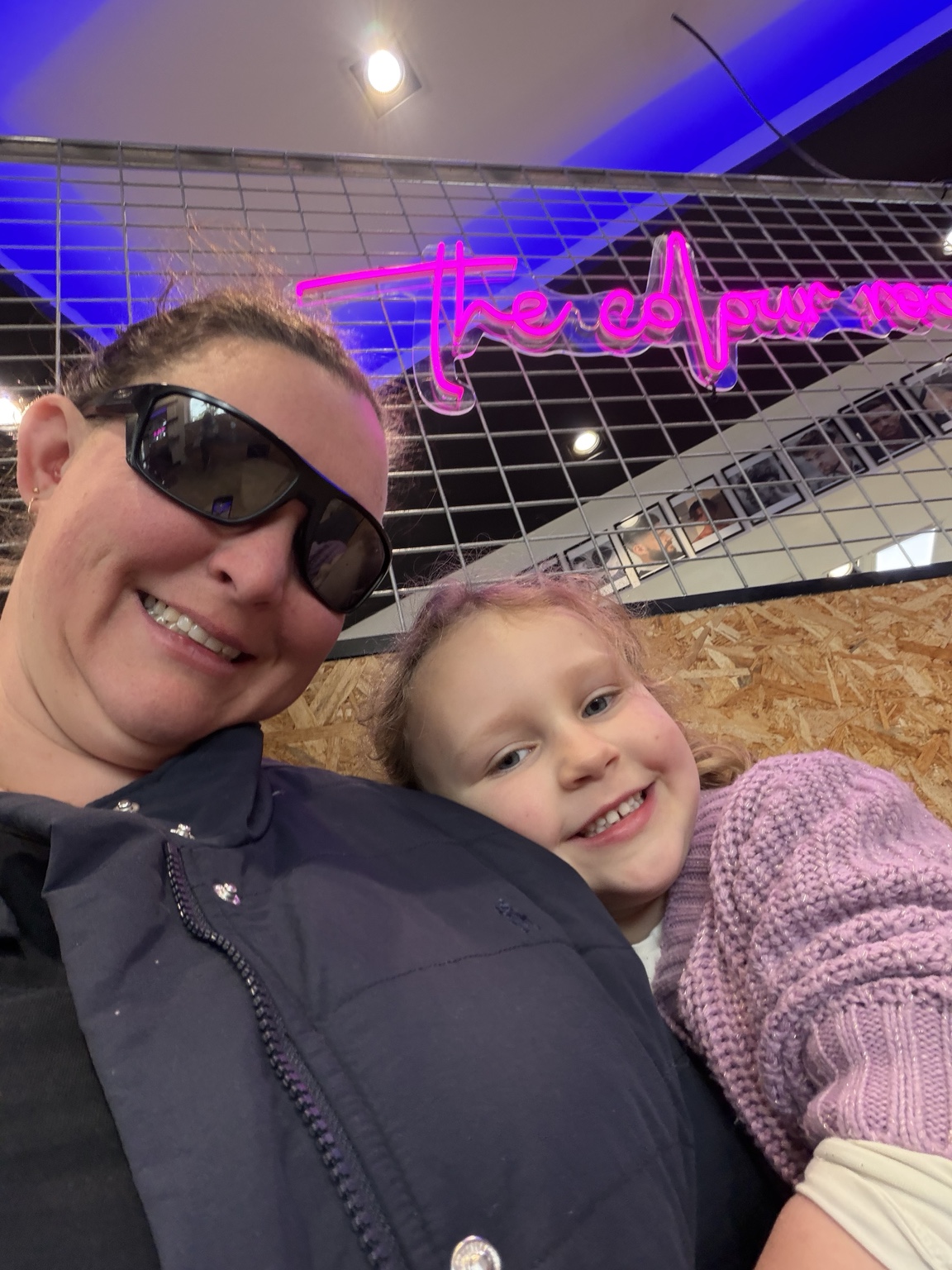 Rachel with Addy indoors, wearing dark sunglasses